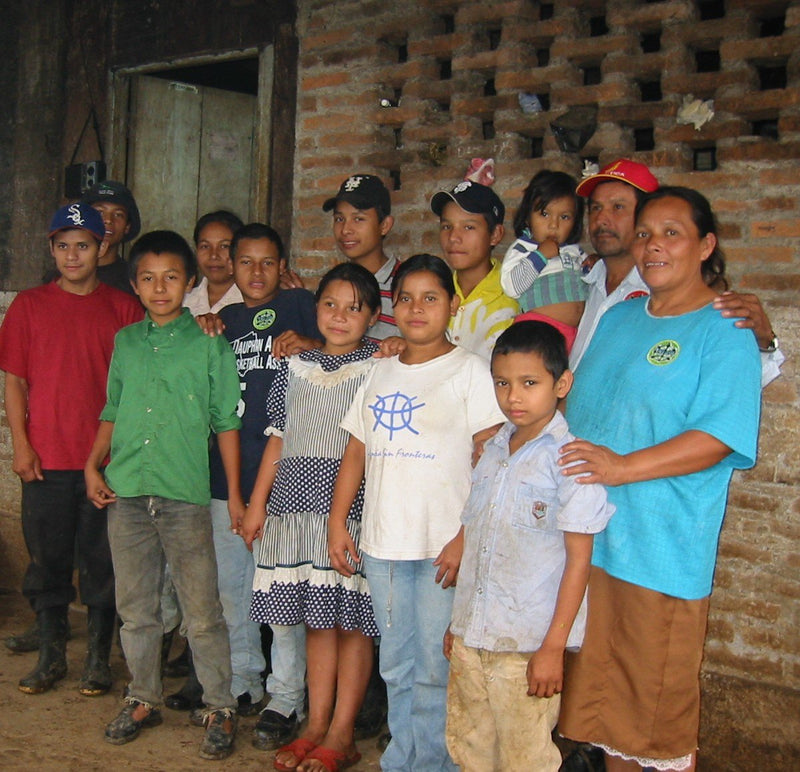 A coffee farming family standing together outside their home